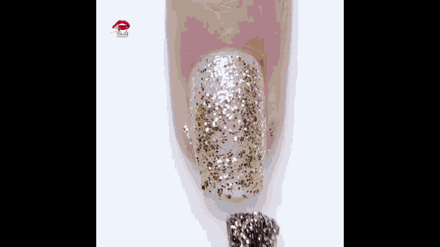 a close up of a nail with glitter on it and a brush next to it
