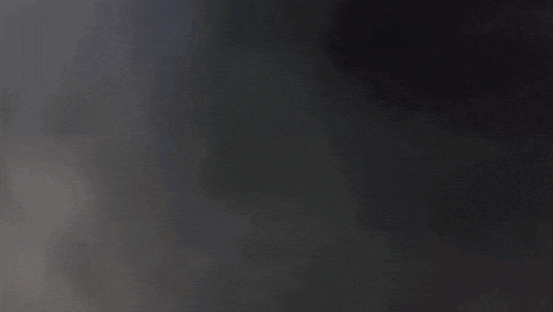 a person is laying on a bed with a white blanket and a black shirt .