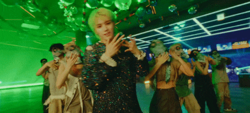 a group of people are dancing in a room with a green background .