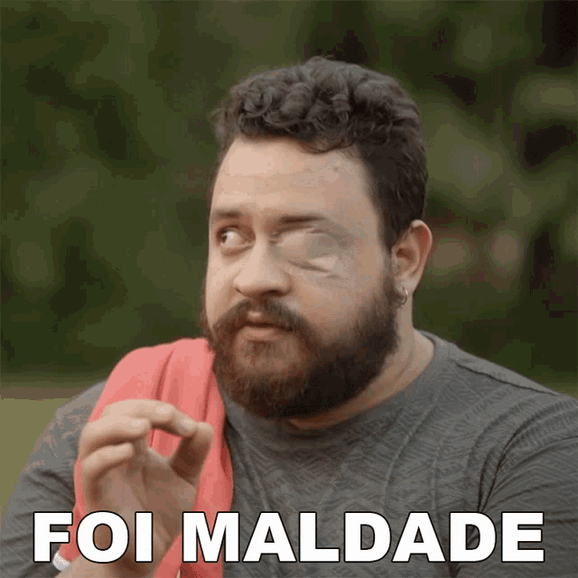 a man with a beard has a bandage on his eye and the words foi maldade behind him