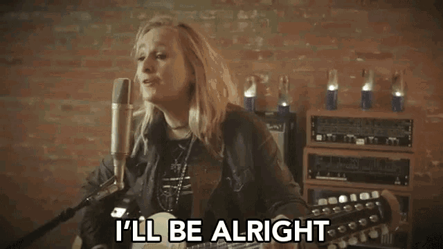 a woman singing into a microphone with the words " i 'll be alright " next to her