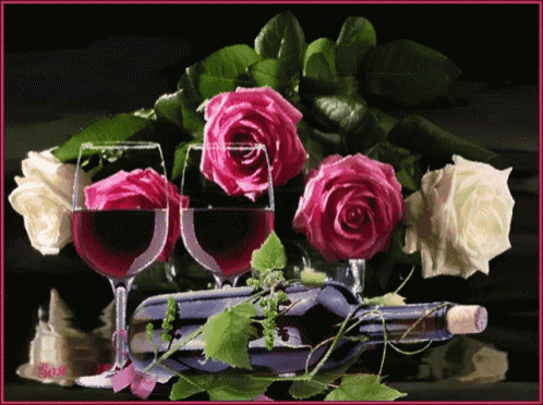 a bottle of wine sits next to two glasses of wine and roses