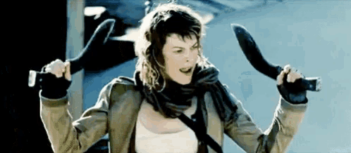 a woman is holding two knives in her hands and screaming .
