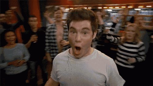 a man with a surprised look on his face in front of a crowd of people