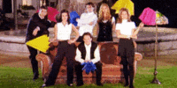 a group of people posing for a picture with umbrellas in the background
