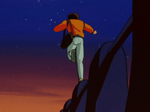 a man in an orange sweater and white jeans is running down a hill