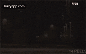 a man is standing in front of a glass door in the dark .