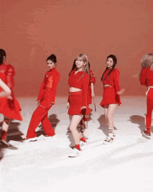 a group of women are dancing in red outfits