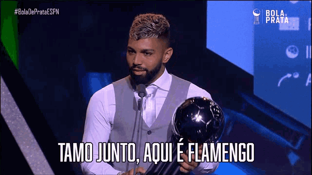 a man holding a trophy that says flamengo on it