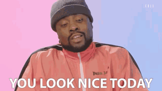 a man wearing a beanie and a pink jacket is saying you look nice today .