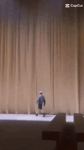 a man is walking across a stage with a caption that says capcut