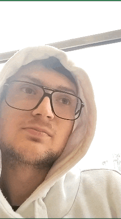 a man wearing a white hoodie and glasses looks at the camera