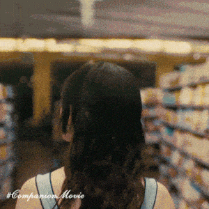 a woman in a blue tank top is standing in a store with the words companion movie on the bottom right