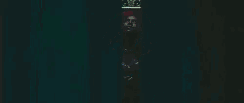 a woman with red hair is standing in front of a mirror wearing a crown .