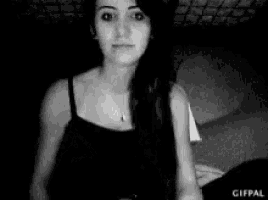 a black and white photo of a woman in a black tank top .