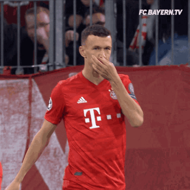 a man wearing a red t-mobile jersey covers his nose