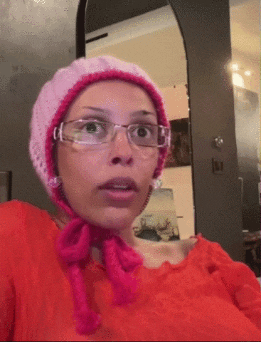 a woman wearing glasses and a pink hat