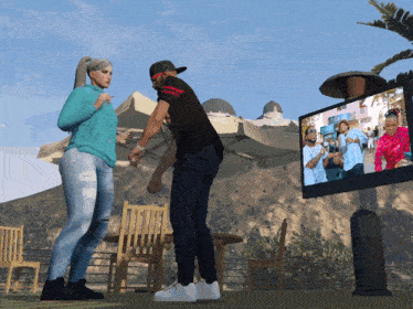 a man and a woman are standing in front of a large television