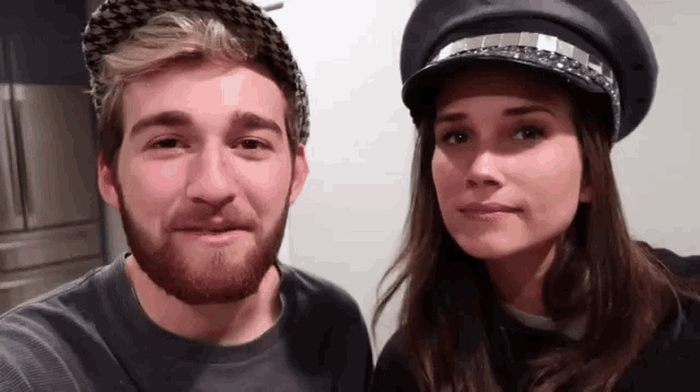 a man with a beard and a woman wearing a hat