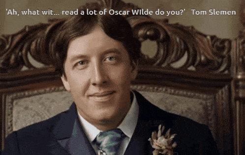 a man in a suit and tie is sitting in a chair with a quote from tom slemen