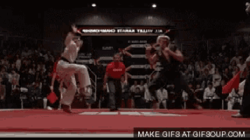 two martial arts fighters are fighting in front of a crowd and the words make gifs at gifsoup.com are visible