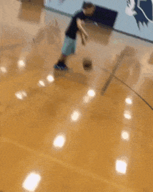 a blurry picture of people playing basketball on a hardwood court