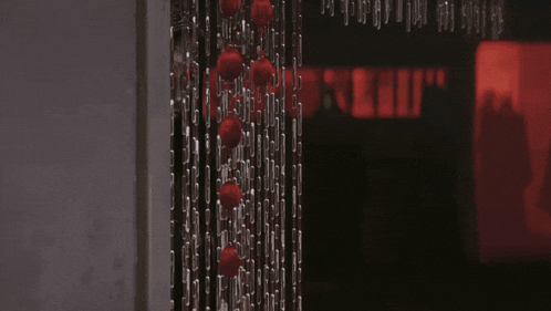 a bunch of red balls are hanging on a string
