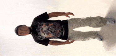 a man wearing a denim t-shirt and khaki pants