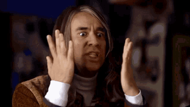 a man with long hair is making a funny face with his hands