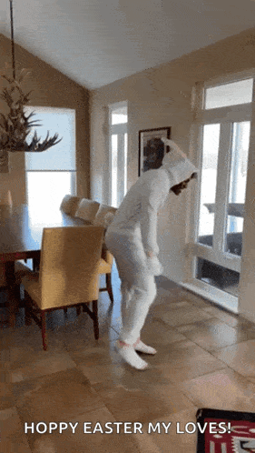 a person in a white bunny costume is dancing in a living room with the caption hoppy easter my loves