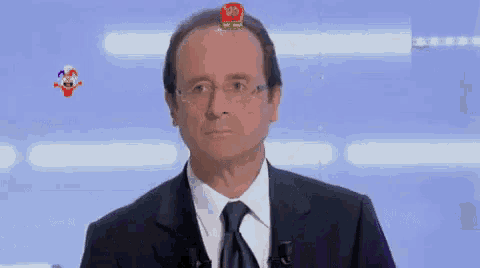 a man in a suit and tie has a toy on top of his head .