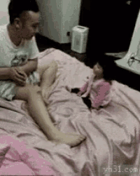 a man is sitting on a bed with a little girl .