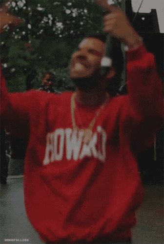 a person wearing a red sweater is standing in front of a crowd of people .