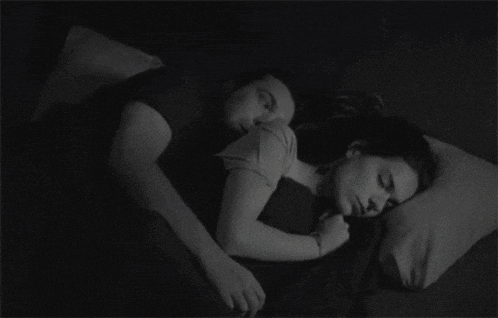 a man and a woman are sleeping together in a dark room