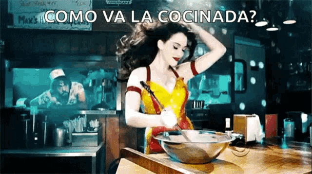 a woman in a wonder woman costume is mixing something in a bowl with the words como va la cocinada behind her