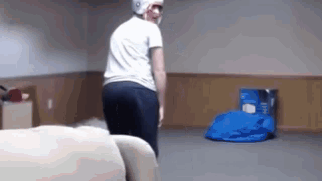 a man wearing a white helmet is standing in a room .