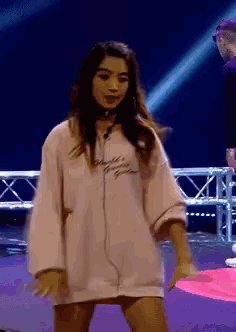 a woman wearing a pink shirt that says ' amanda ' on it is dancing on a stage