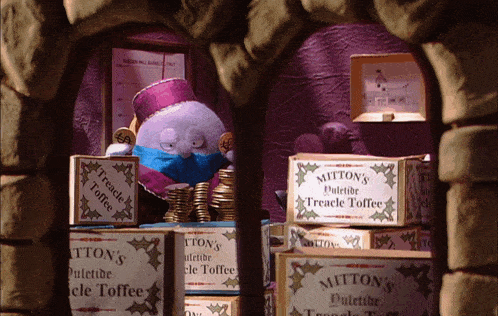 a box of mitton 's dulette toffee sits on top of a pile of other boxes
