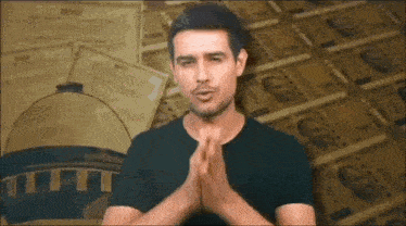 a man with his hands folded in front of a pile of money