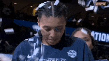 a woman wearing a blue shirt that says ncaa women 's basketball on it