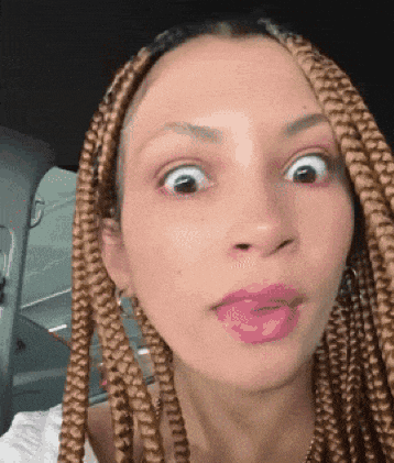 a woman with braided hair is making a funny face