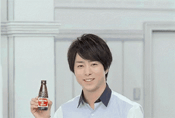a man in a blue shirt is holding a bottle of soda