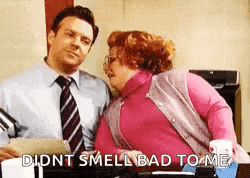 a man and a woman are kissing in an office .