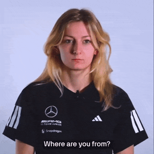 a woman wearing a black shirt that says amg f1 team junior on it