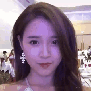 a woman wearing purple earrings looks at the camera