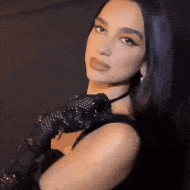 a close up of a woman wearing black gloves and a black dress .