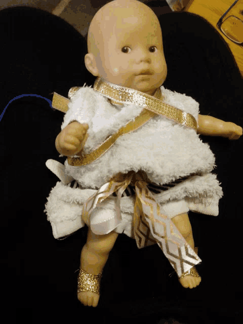 a baby doll is wrapped in a white towel and ribbon