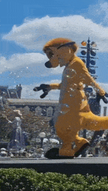a meerkat mascot is walking down a street with soap bubbles coming out of it .