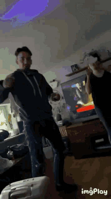 a man and a woman are dancing in front of a tv with a purple light behind them