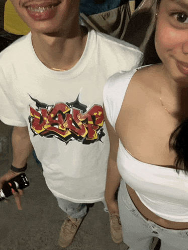 a man and a woman are posing for a picture and the man is wearing a t-shirt that says " dan " on it